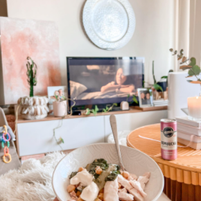 Instagram image of a man and woman laughing, and eating their Nourish'd meals side by side at a white kitchen counter.