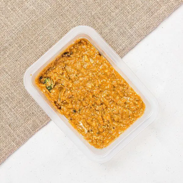 Container shot of the Bacon & Jalapeño Soup, perfectly sealed for convenience. The container showcases the rich orange hue of the soup, with hints of bacon and jalapeño visible for added appeal.