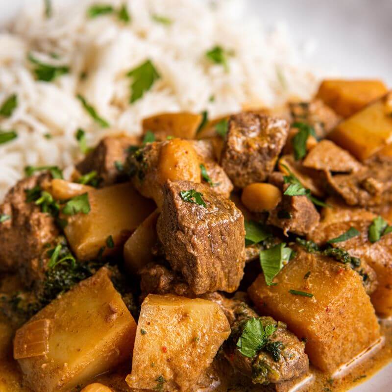 Close-up shot of the Beef Massaman, focusing on the tender beef and rich curry sauce, highlighting the texture and richness of the dish.