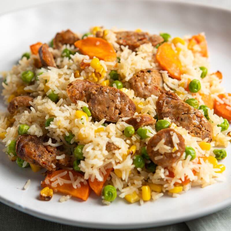A close up photograph of our take on the classic fried rice, served on a white ceramic plate.