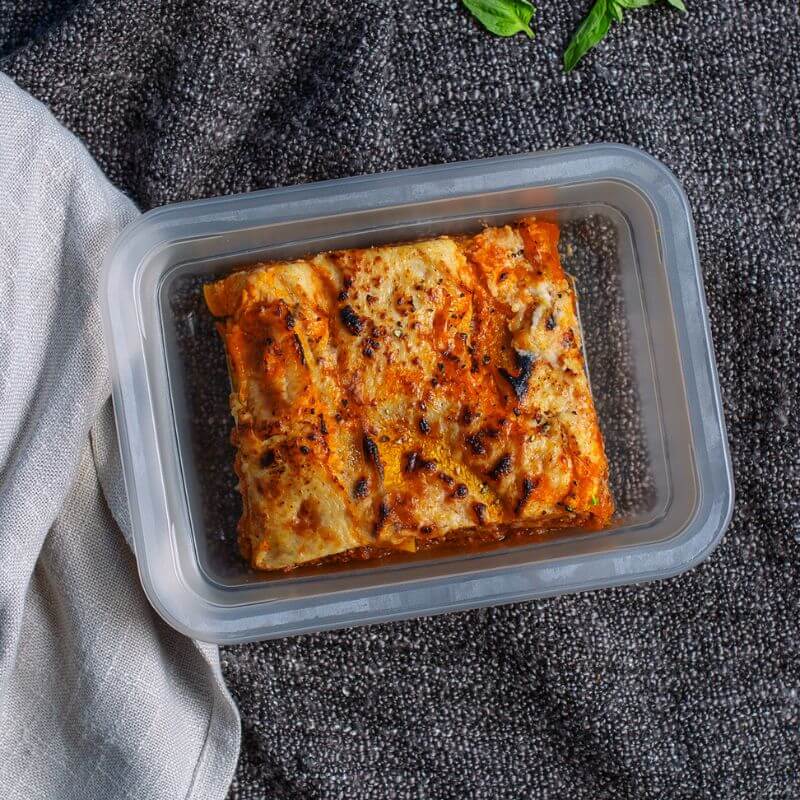 Container shot of the Pumpkin Lasagna, served in a clear container, with a simple, clean background to emphasize the dish's appearance.