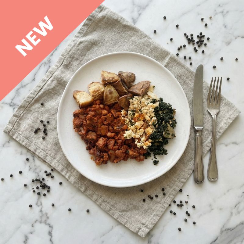 Flat lay shot of the All Day Big Breakfast on a white plate, showcasing chorizo, herby scrambled eggs, smoky baked beans, and crispy potato hash, all perfectly arranged.